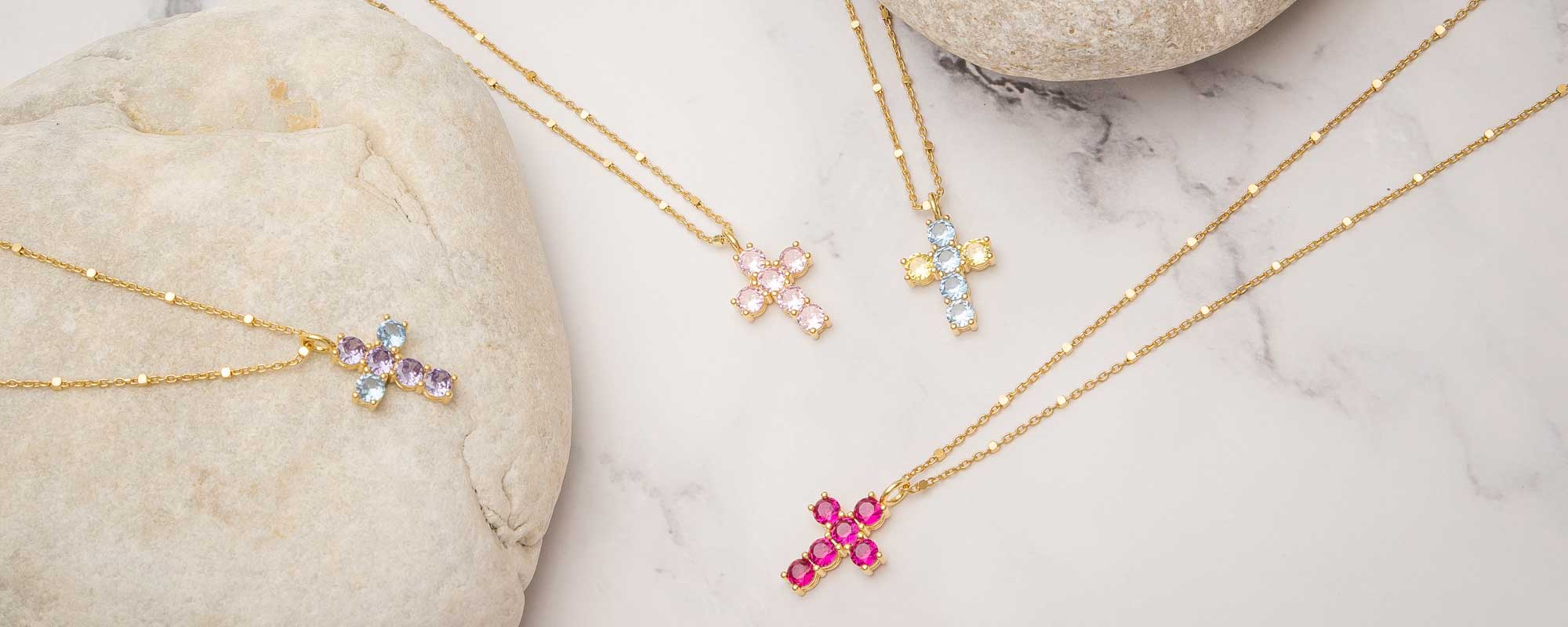 Cruces fabricadas en oro y plata bañada con circonitas.